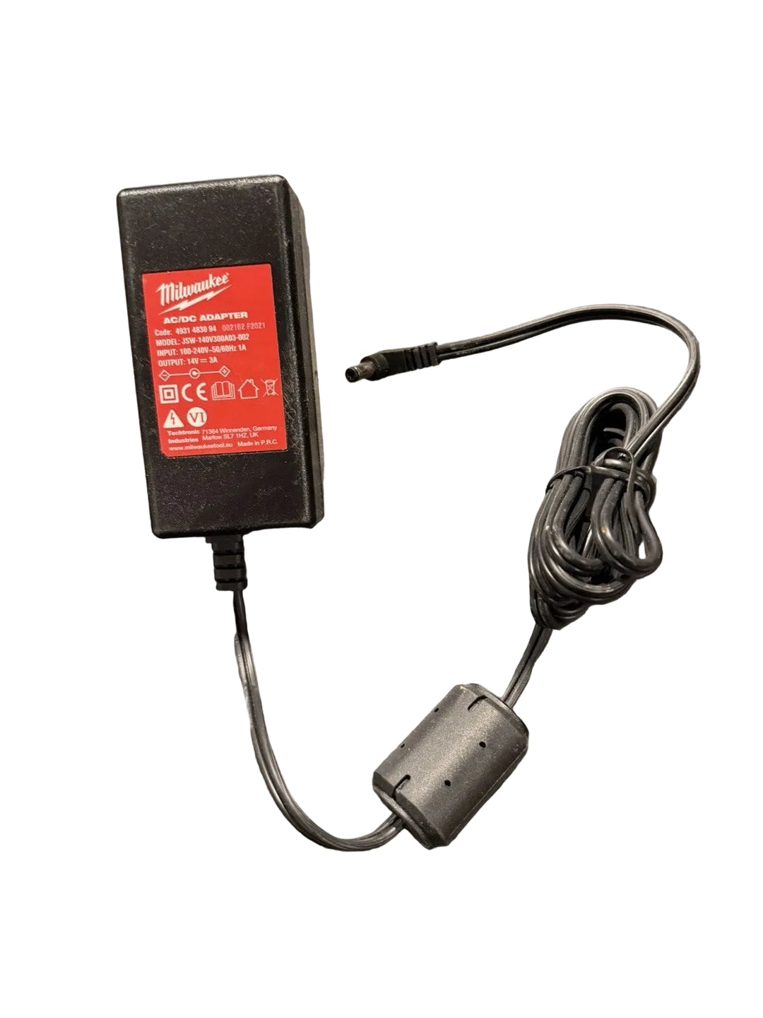 A Milwaukee 110V AC/DC adapter with a black rectangular power block, a red brand label, and a coiled black power cord on a dark speckled countertop.